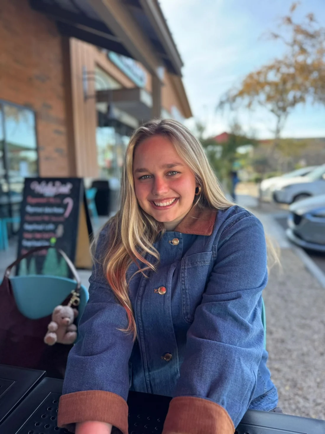 Sondra, the baker behind Crunchy Loaf, smiling at an outdoor café